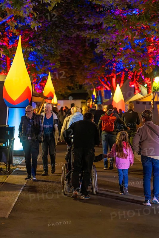 People at a colourful city festival at night with illuminated trees and stalls, Sindelfingen, district of Böblingen, Germany