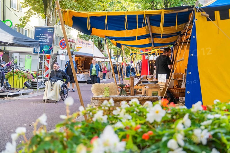 Colourful market scene with tents, flowers and people in motion, Sindelfingen, Böblingen district, Germany