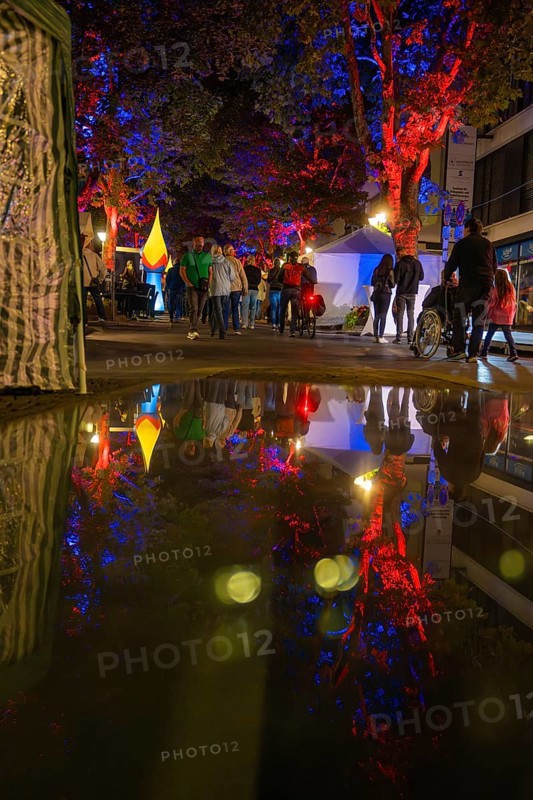 Colourful night lights reflected in a rain-soaked street during an event, Sindelfingen, Böblingen district, Germany