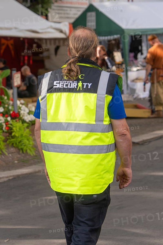 Person in yellow safety waistcoat on a market square, Sindelfingen, Böblingen district, Germany