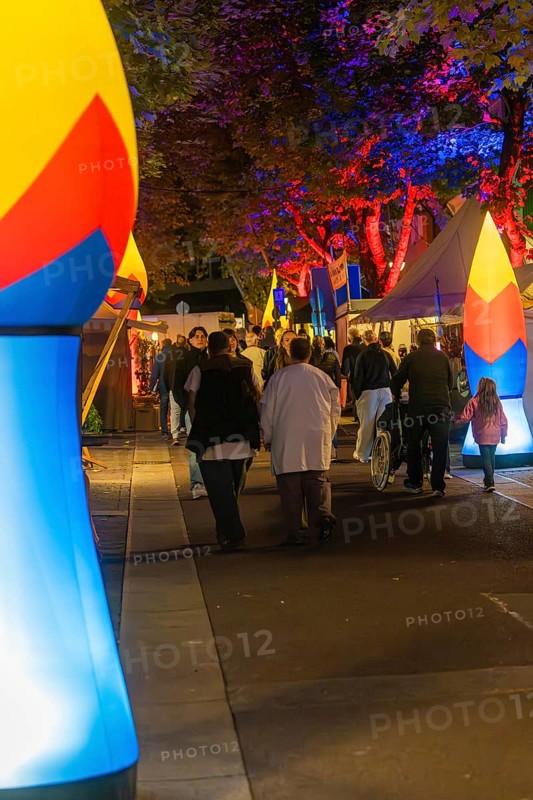 People walking at night on a street illuminated with colourful lights, Sindelfingen, Böblingen district, Germany