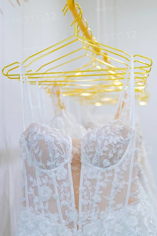 White lace wedding dresses hang elegantly on yellow hangers, Sindelfingen, Böblingen district, Germany