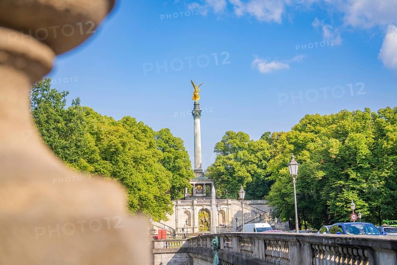 Golden lace statue on column, flanked by relevant bridge structure and greenery in summer, Munich, Germany