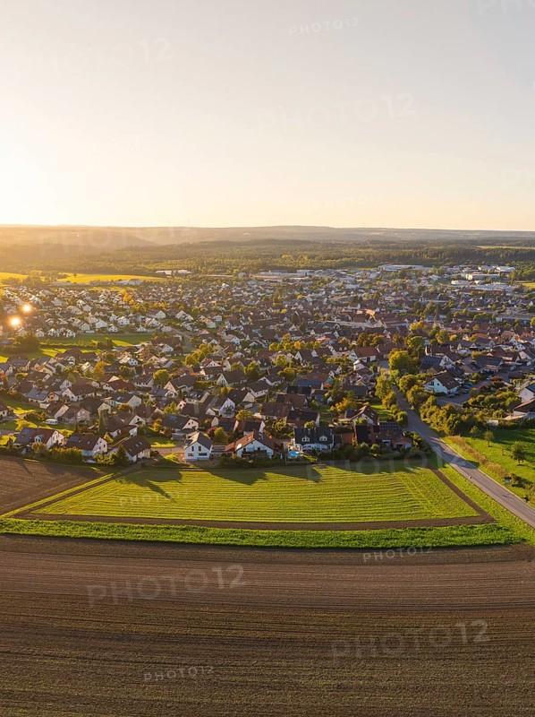 Aerial view of a village surrounded by fields at sunset with rural charm, Althengstett, district of Calw, Germany
