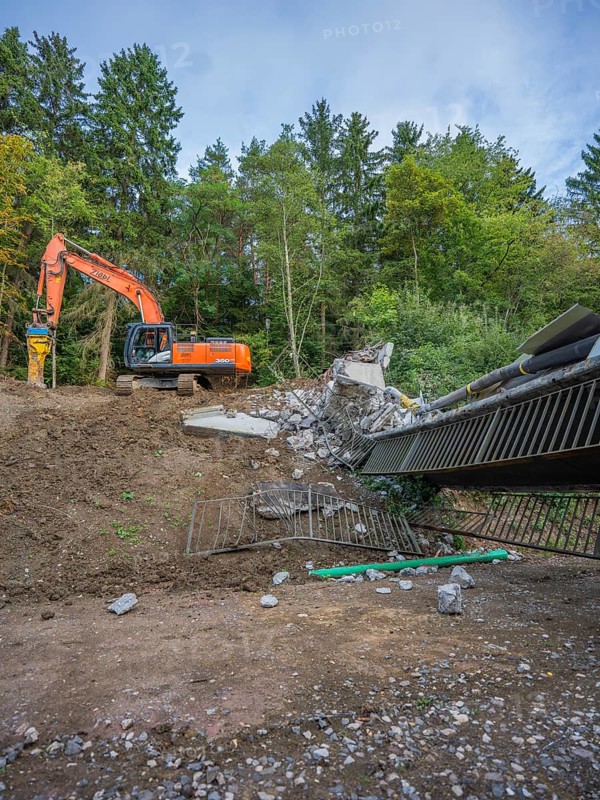 An excavator is demolishing a bridge in a wooded area, bridge demolition, Calw, Germany