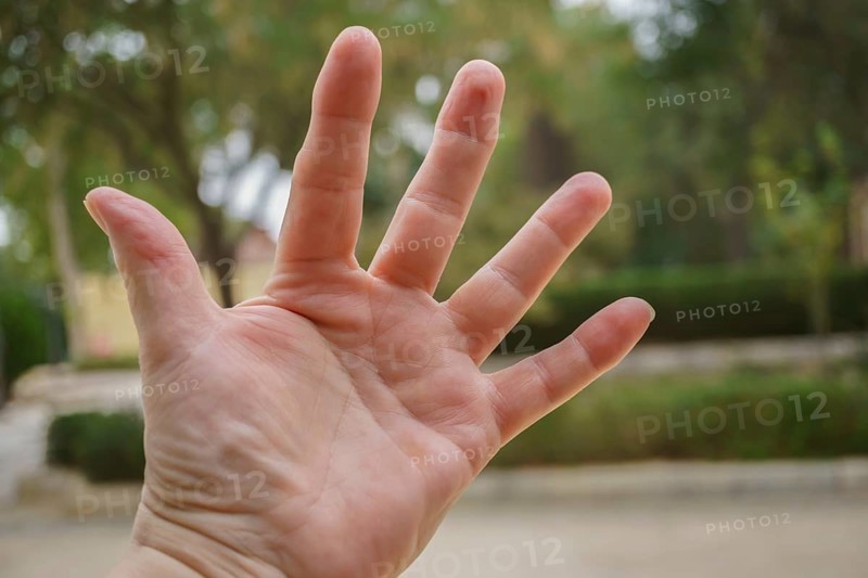 Open hand showing five fingers with a nature background in ronda, malaga, spain