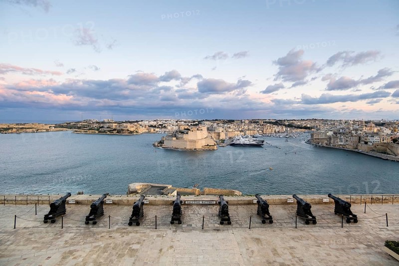 Beautiful sunset view of Valletta with a cannons in the foreground, capital city of Malta