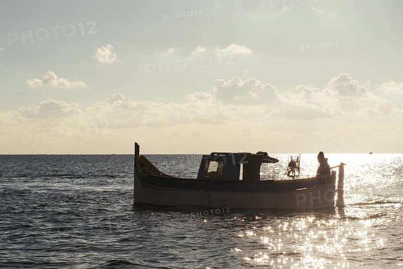 Silhouette of Maltese boat on Mediterranean Sea by Marsaxlokk, south of Malta
