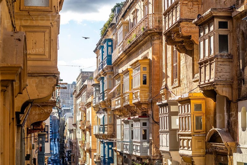 Street with amazing historic houses with colorful wooden balconies in La Valletta, capital city of Malta