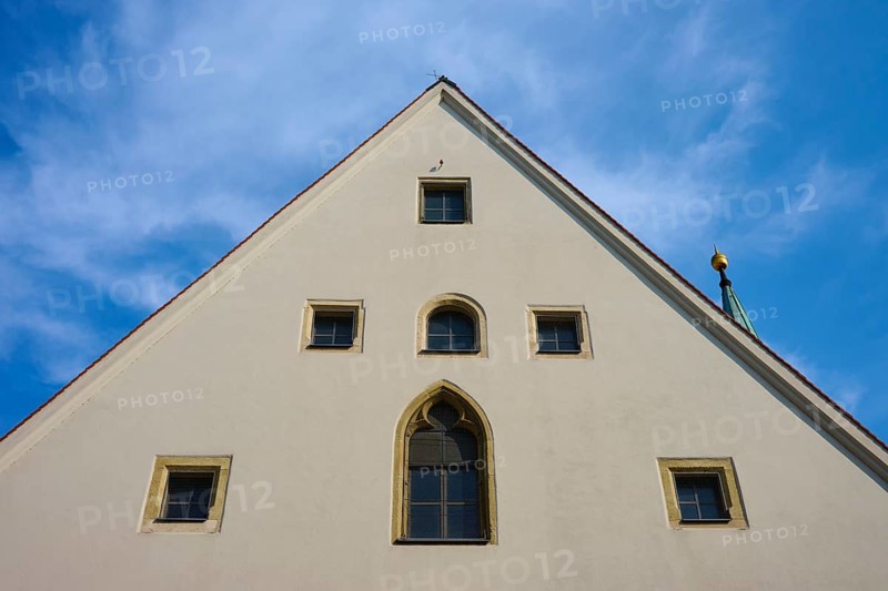 Gable of an old building with Gothic windows in front of a blue sky, Regensburg, Bavaria, Germany