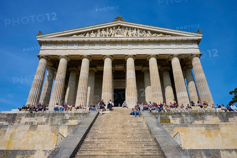 Temple-like structure with monumental columns and visitors on a staircase under a blue sky, Walhalla, Donaustauf, Regensburg, Bavaria, Germany