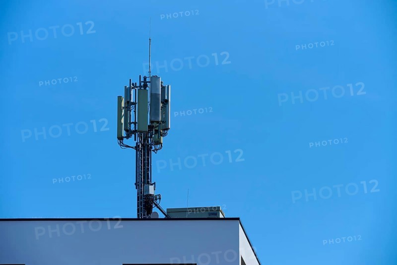 Communication tower on the roof of a building under a clear blue sky, Regensburg, Bavaria, Germany