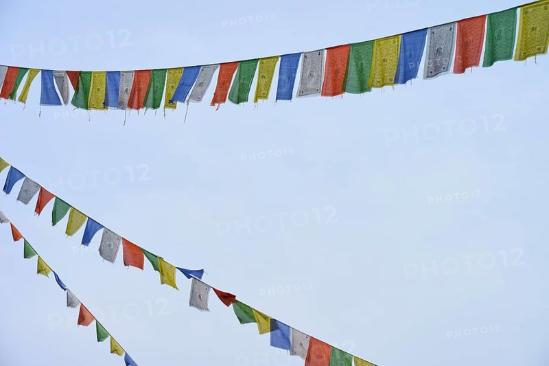 Colourful prayer flags waving gently against the blue sky and creating a meditative atmosphere, Bavaria, Germany