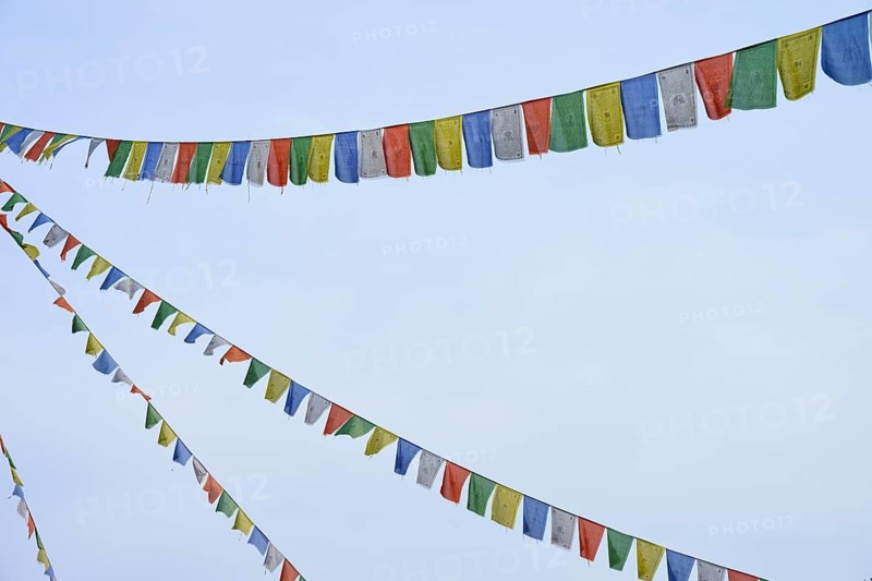 Colourful prayer flags flutter in the blue sky, conveying a feeling of freedom and peace, Bavaria, Germany