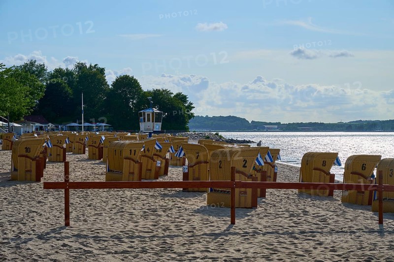 Beach chairs on a quiet beach with blue sky and water in the background under the summer sun, Heikendorf, Kreis Plön, Kieler Förde, Schleswig-Holstein, Germany