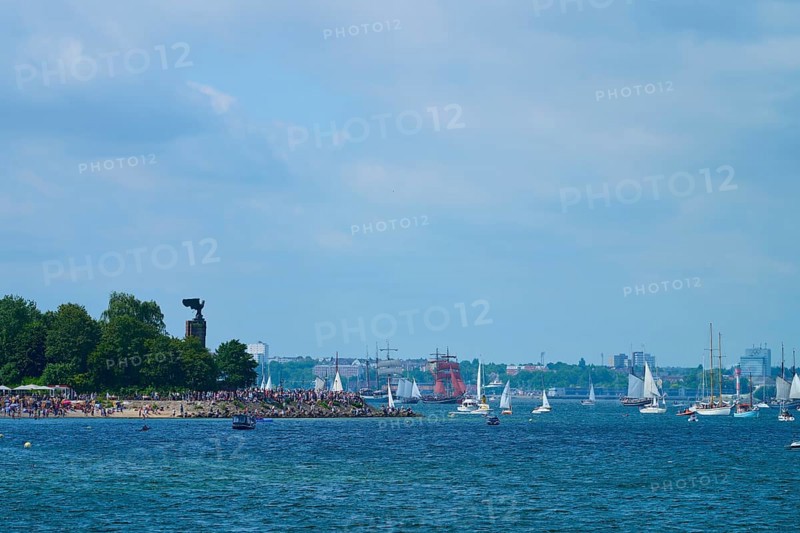 Boats and yacht on the sea near a tree-covered shore with people, Windjammer Parade Kiel 2025, Heikendorf, Plön district, Kiel Fjord, Schleswig-Holstein, Germany