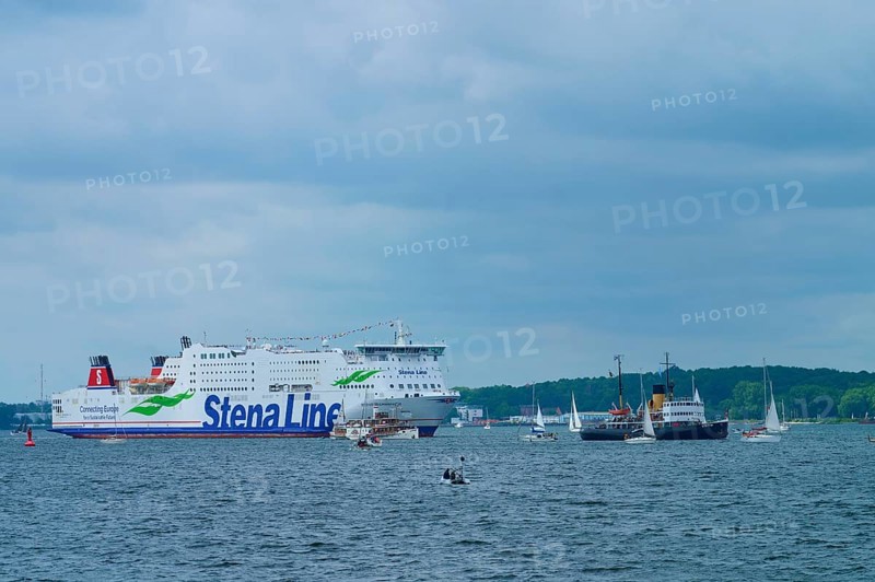 Stena Line ferry and historic ship in a sea travelled by sailing boats with cloudy sky, Windjammer Parade Kiel 2025, Heikendorf, Kreis Plön, Kieler Förde, Schleswig-Holstein, Germany