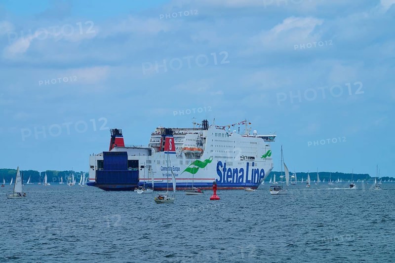 Large ferry on the sea surrounded by sailing boats under a blue sky, Windjammer Parade Kiel 2025, Heikendorf, Plön district, Kiel Fjord, Schleswig-Holstein, Germany