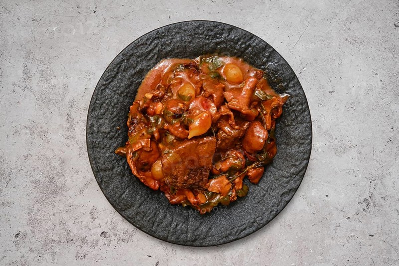 A hearty beef stew featuring tender chunks of meat and fresh vegetables sits invitingly on a textured black plate