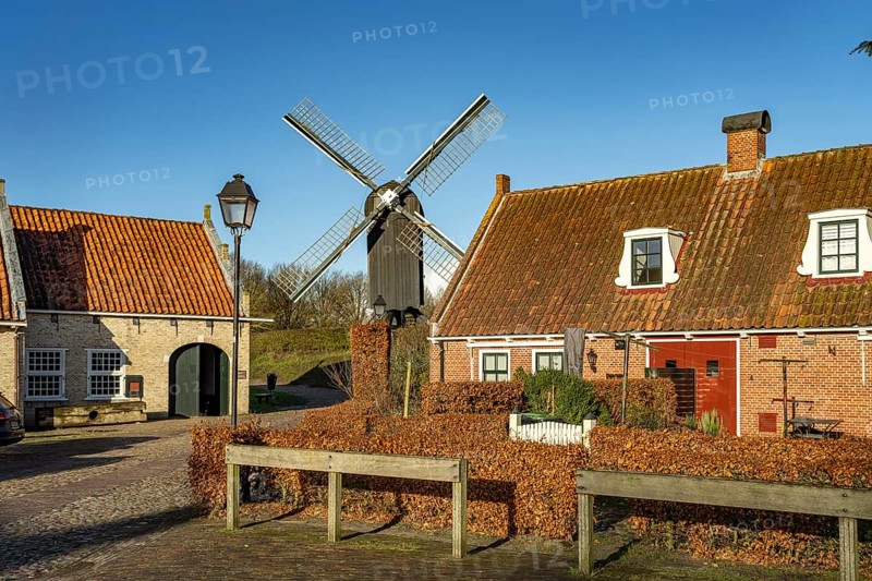 Traditional houses and windmill of the inhabited former fortress of Bourtange, Groningen, Netherlands