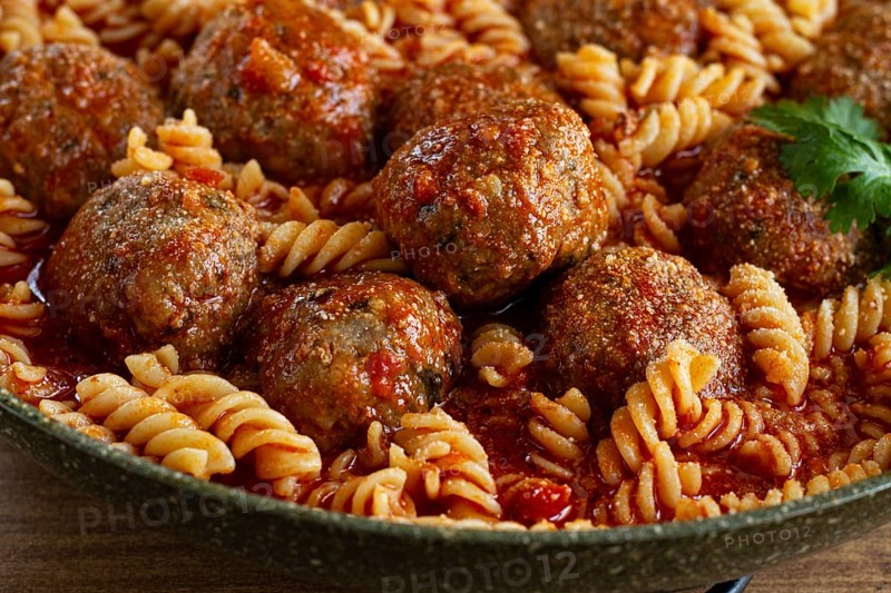 Minced meat meatballs, in tomato sauce, with fusilli pasta, in a cast-iron pan, homemade, no people