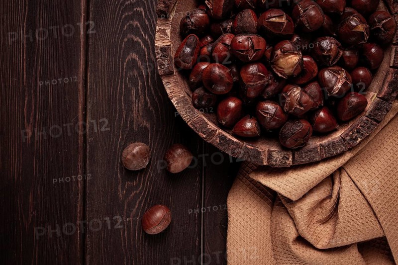 Roasted chestnuts, in a wooden plate, top view, homemade, no people