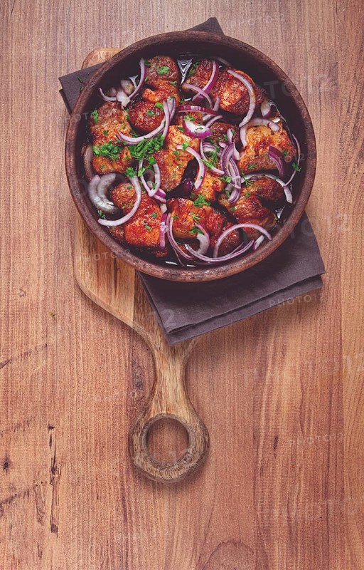 Fried meat, pork kebab, ketsi in a clay pan, with red onions and herbs, homemade, no people