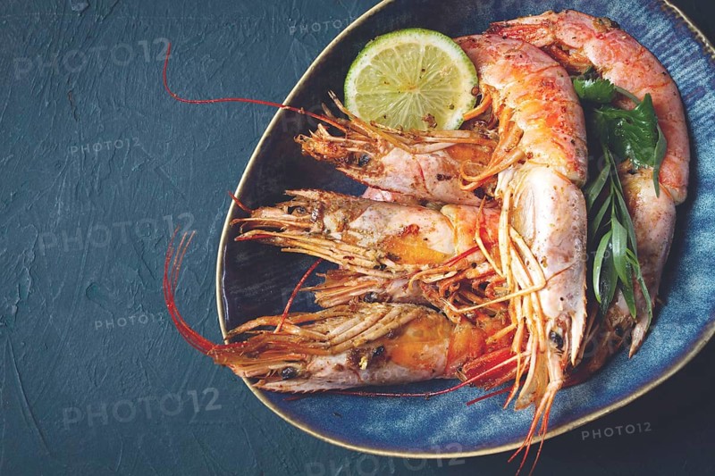 Langoustines, Australian, freshly frozen on ice, top view, lime and greens