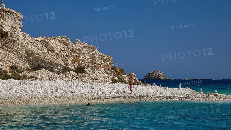 Rocks and a pebble beach meet turquoise waters under a clear sky, White Cliffs, White Beach, Makri Aspronisi Island, Natura 2000 area, boat trip, Aspronisi, Lipsi, Dodecanese, Greek Islands, Greece