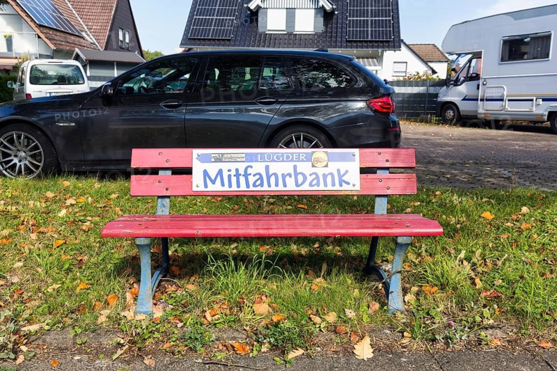 Red bench at the roadside, sign with inscription Mitfahrbank, Mitfahrerbank, symbol photo, carpool, free of charge, hitchhiking, ecology, traffic load, rural area, Lügde, Weserbergland, North Rhine-Westphalia, Germany