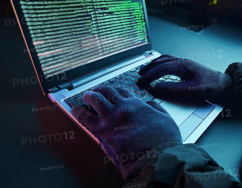 Cybersecurity threat depicted by gloved hands operating a computer, commands displayed on the screen. Represents hacking, data theft, and online crime concepts with a dramatic atmosphere, AI generated