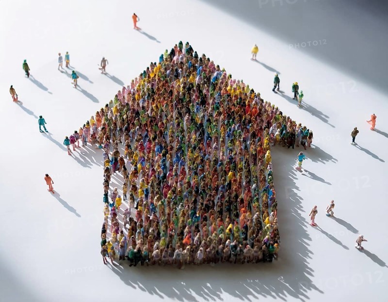 A concept photograph depicting numerous individuals arranged to form the shape of a house. Symbolic representation of community, shelter, cooperation, and housing solutions in a creative visual format, AI generated