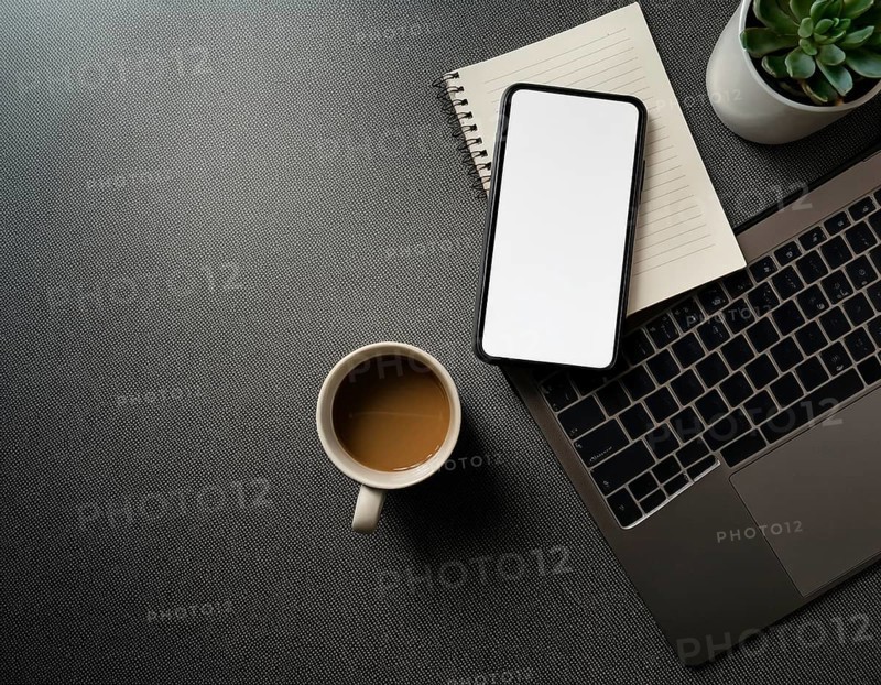 Op view of an organized workspace featuring a laptop, smartphone, notebook, pen, plant, and coffee emphasizing minimalism, productivity, modern work environments, AI generated