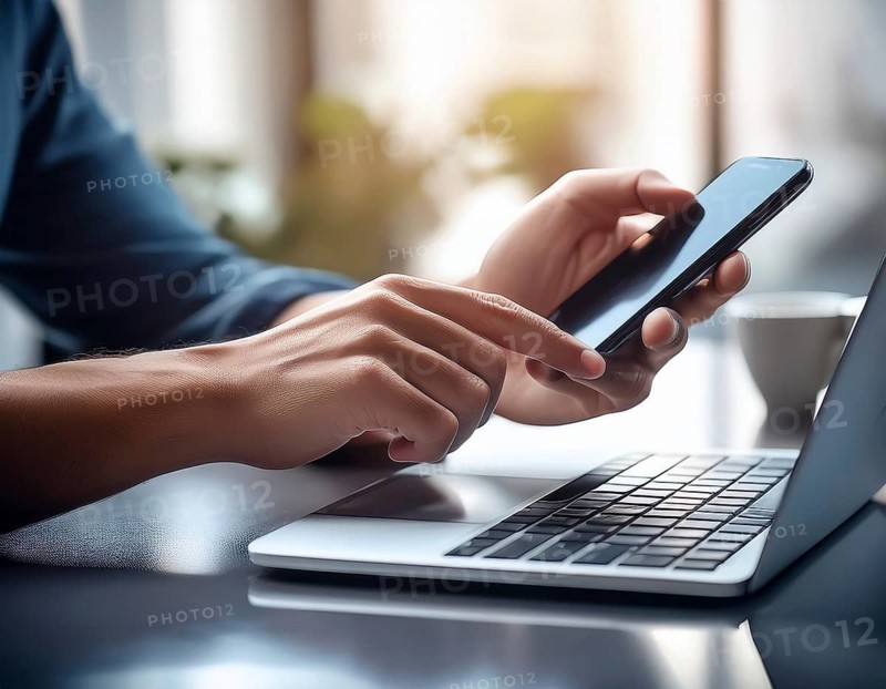 A man in a professional office environment multitasking with a smartphone and laptop, conveying productivity, technology integration, and modern working practices, AI generated