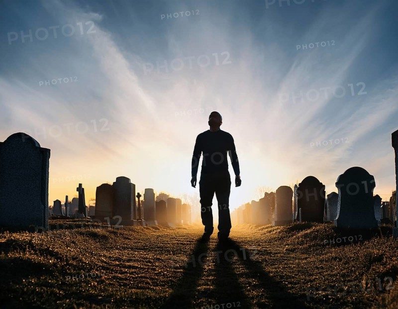 A silhouette of a lone figure walking off a gravestone, The scene evokes Resurrection thoughts emotional depth, AI generated