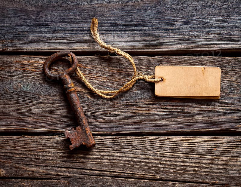 A close-up of an ornate vintage key with a blank label attached, resting on a brown surface under soft, warm light, evoking a sense of mystery, history, and curiosity, AI generated