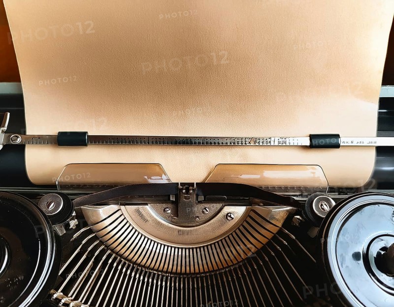 View from above of a retro typewriter equipped with a blank paper sheet, representing creativity, literary work, and nostalgia for traditional written communication methods, AI generated