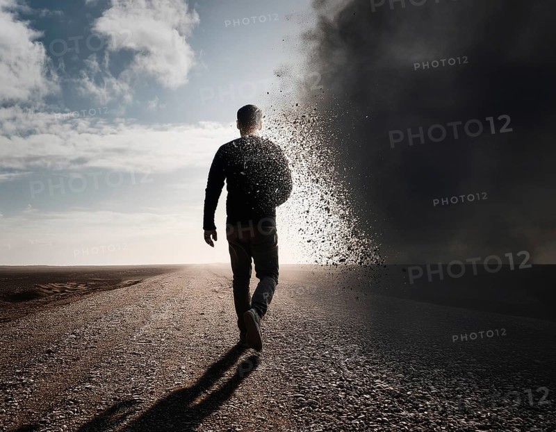 Creative image showing a silhouette of a man merging with an abstract dispersion effect and dramatic light, symbolizing transformation, disintegration, creativity, and inspiration with a focus on artistic exploration, AI generated