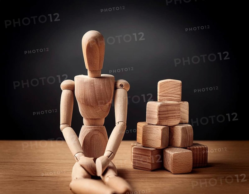 A wooden mannequin seated at a table conveys emotions of stress, thought, and contemplation. Captivating imagery that embodies serene introspection and personal challenges, AI generated
