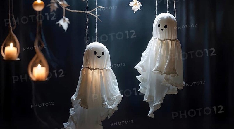 Two hanging ghost decorations with happy faces and candles, creating a whimsical Halloween atmosphere. AI generated