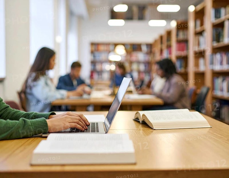 University students studying with open books and laptops, symbolizing education, collaborative learning, academic success, and teamwork, AI generated