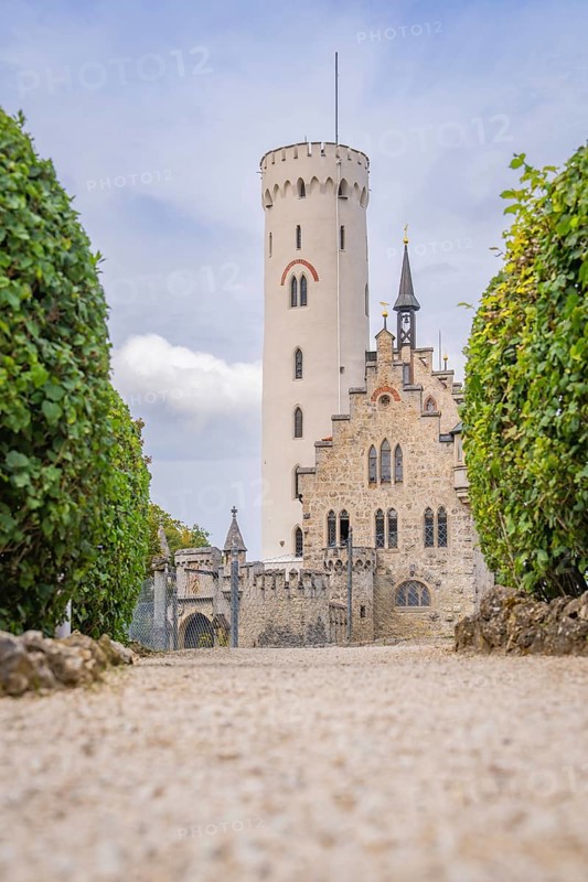 Majestic castle with towers and manicured hedges, captured from a view along a cobbled path, Lichtenstein Castle, Lichtenstein, Swabian Alb, Germany