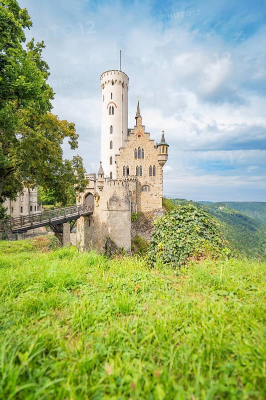 Medieval castle on a grassy cliff, surrounded by a picturesque landscape and dramatic sky, Lichtenstein Castle, Lichtenstein, Swabian Alb, Germany