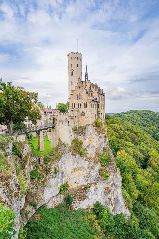 Castle stands impressively on a green cliff under a blue sky, Lichtenstein Castle, Lichtenstein, Swabian Alb, Germany