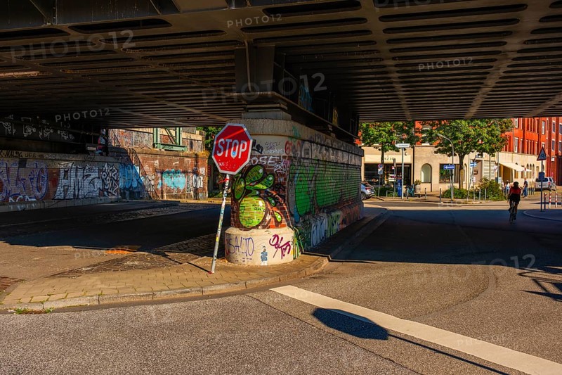 View of parts of a road leading under the Oberhafen Bridge and of the abutment painted with graffiti, people as gnomes, Hamburg, Germany