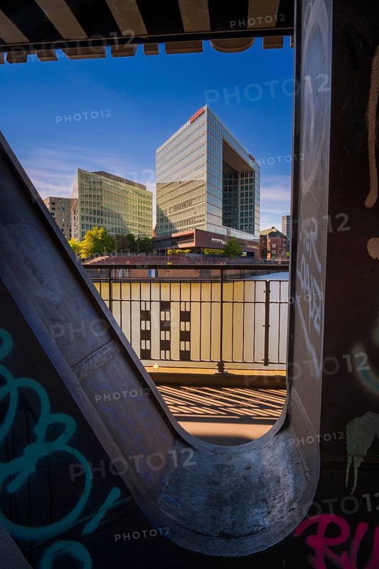 Long-term photograph of the mirror building through a steel girder of the Oberhafenbrücke bridge at Oberehafen and Ericusgraben, Hamburg, Germany