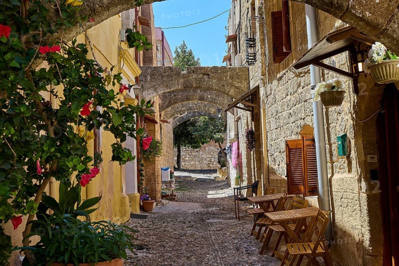Idyllic, flower-filled alleyway with arches and old stone buildings in historic style, Turkish Quarter, Rhodes Old Town, Rhodes Town, Rhodes, Dodecanese, Greek Islands, Greece