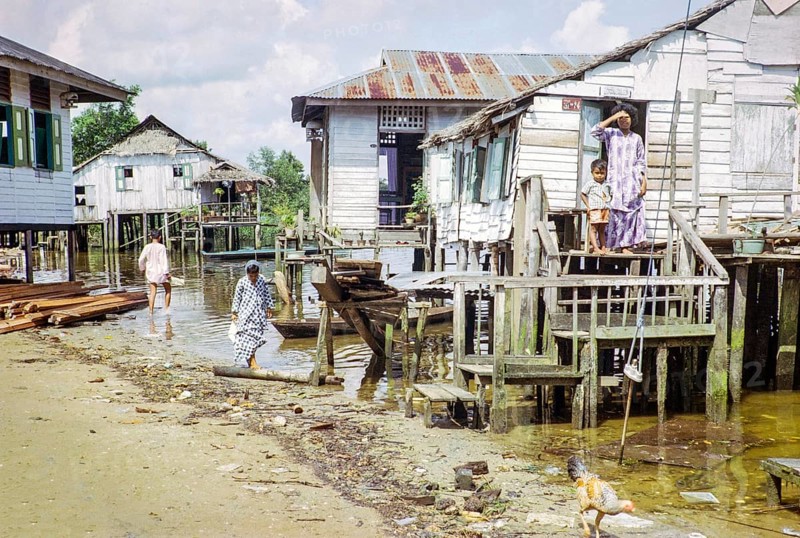 Houses on stilts above sea water in coastal village of Kampong Lorong Fatimah in Singapore, Southeast Asia c 1964