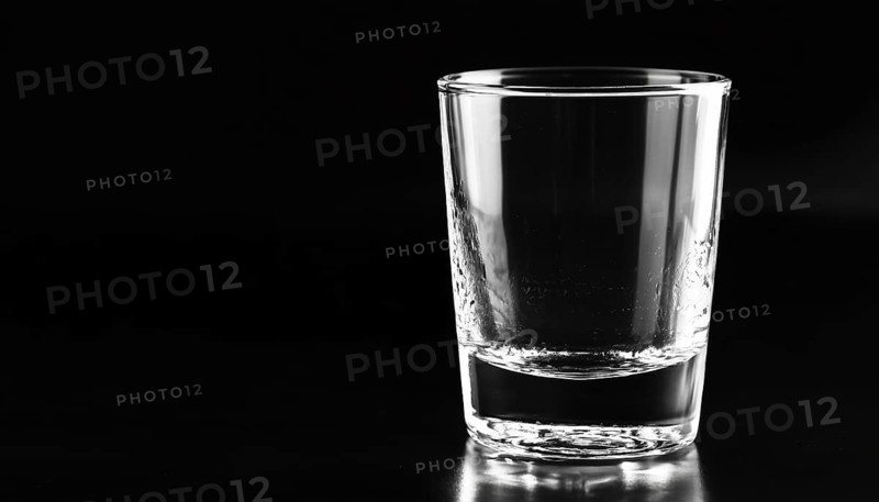 Black Background Showcasing A Lone, Empty Glass In The Foreground. The Stark Contrast Between The Two Elements Creates A Striking Composition, AI generated