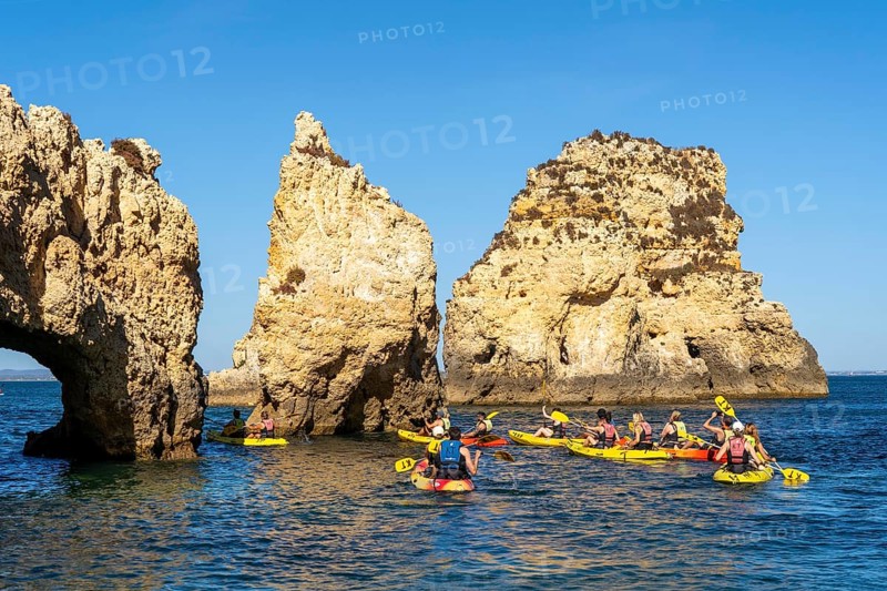 Tour with sea kayaks to the Ponta da Piedade rocky coast, rugged coastal landscape, right next to the city centre of Lagos, in the west of the Algarve, Portugal